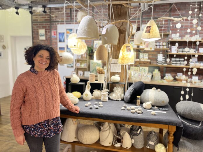 Caroline Morel devant un présentoir de la boutique Hop Là