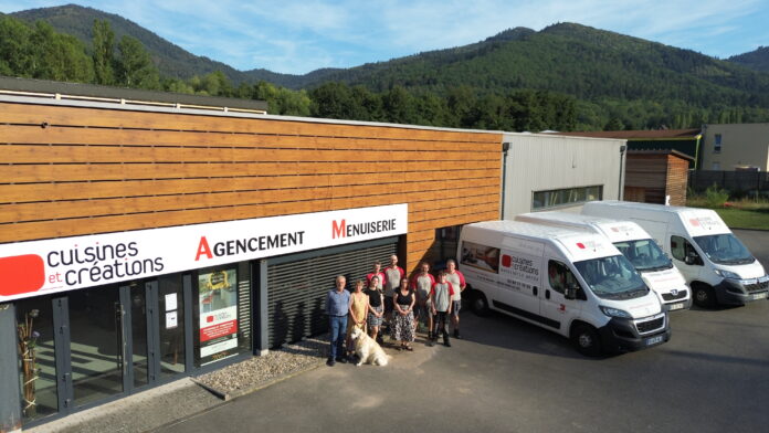 Yvan Wende et ses équipes devant le magasin, accompagnés du chien Barry, la mascotte